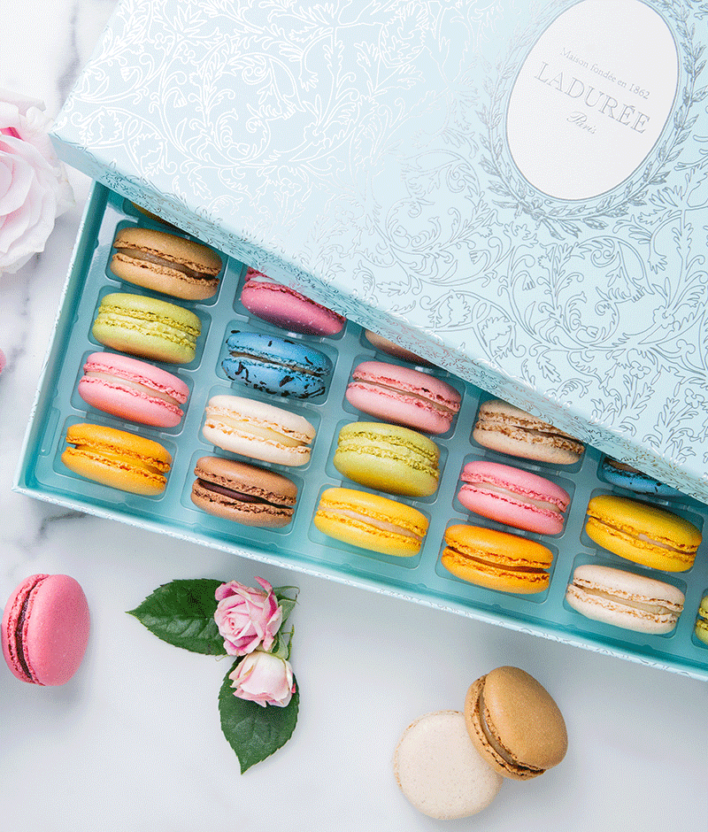 La Maison Ladurée's signature "Arabesque" motif is featured on a box of 42 macarons in a silver version on a blue background.